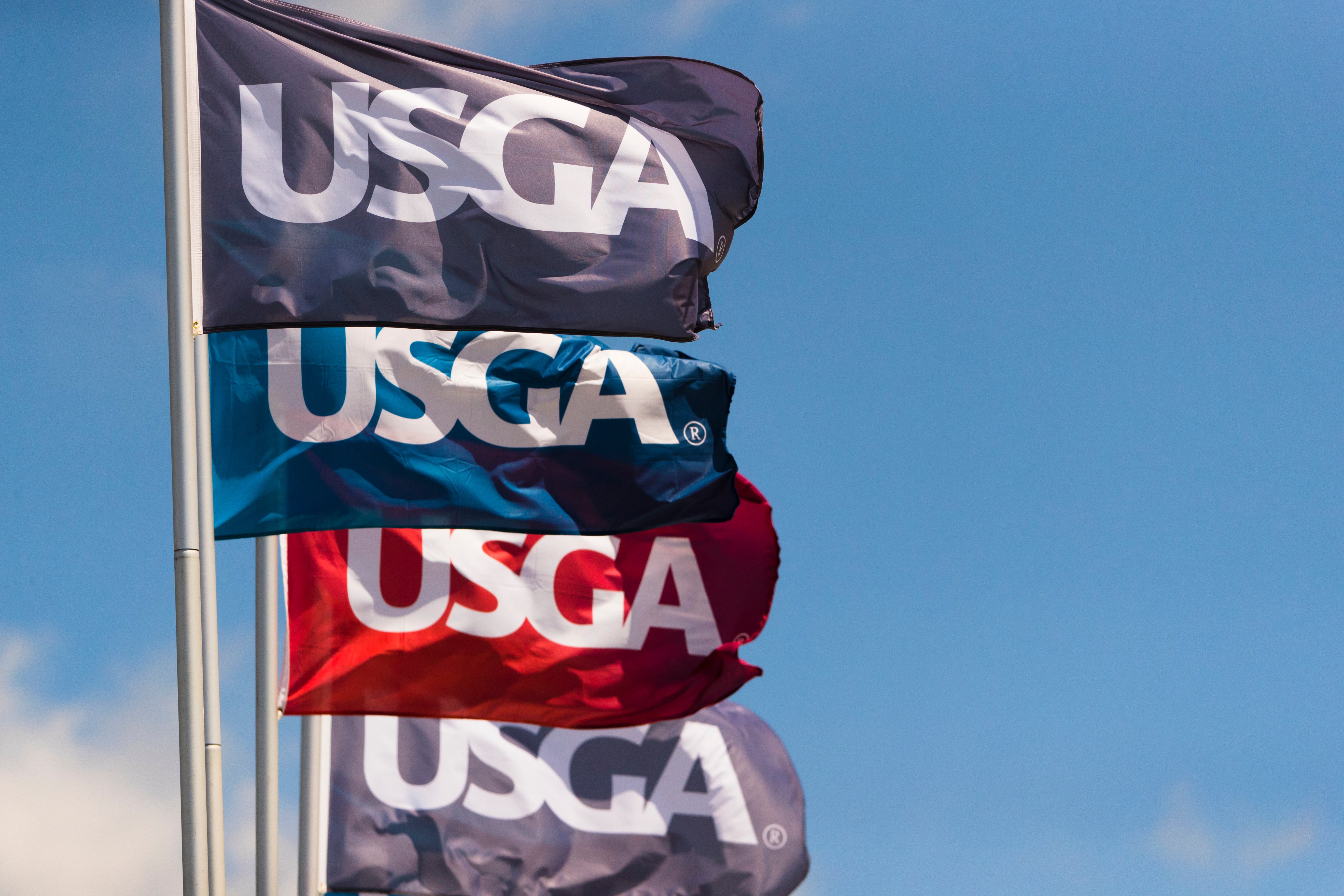 USGA Flags in gray, blue, and red waving in the wind